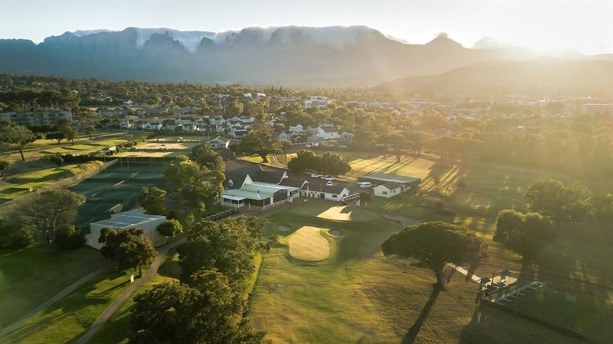 Aerial view of the Somerset West Country Club golf course at sunrise, with the Helderberg mountains beyond