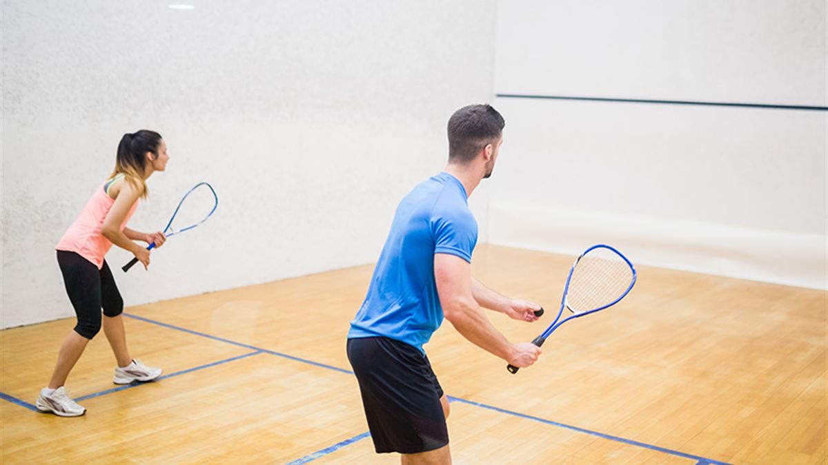 Two players mid-rally on a squash court at Somerset West Country Club